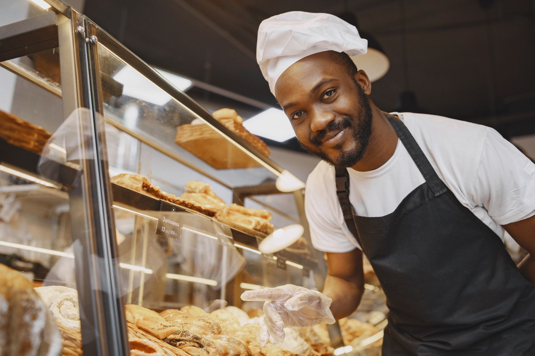Boulanger présentant des pains frais au comptoir