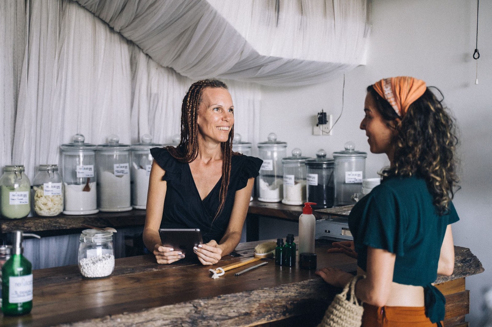 Commerçante au comptoir de sa boutique préparant le contenu de son futur site sur un ordinateur portable